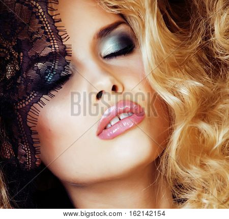 Portrait of beauty blond young woman through black lace close up glamorous concept