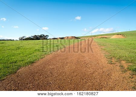 clear blue sky over farmland landscape. Panoramic picture with green fields and a rural country road.
