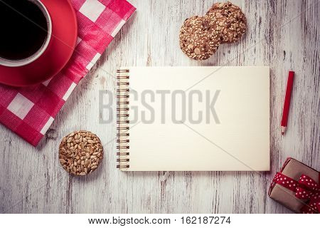Recipe notebook coffee cup and cookies top view on wooden table