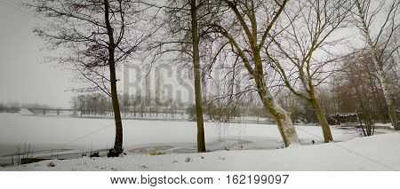Rossiya.Leningradskaya area Sestroretsk: 17.12.2016: In the foreground trees, in the background the church by the lake