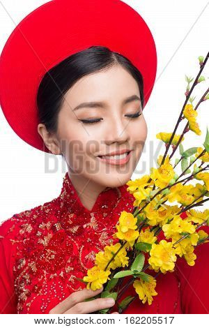Portrait Of A Beautiful Asian Woman On Traditional Festival Costume Ao Dai Holding Hoa Mai Tree (och