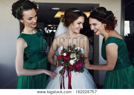 Beautiful bridesmaids making fun with amazing bride