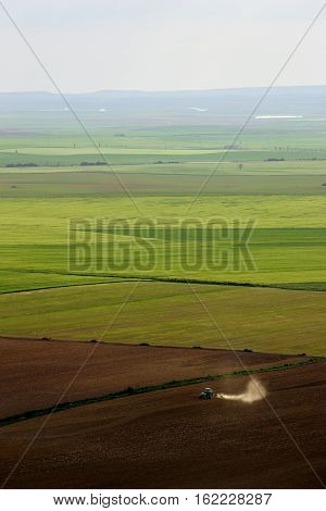 Aerial view of a tractor working a large farming area in Valladolid Spain