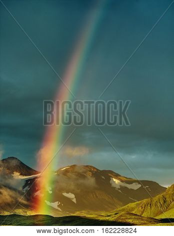 Travel to Iceland. Beautiful sunset in camping near Alftavatn lake. Icelandic landscape with mountains, sky and clouds. Trekking in national park Landmannalaugar. Rainy Evening with big rainbow.