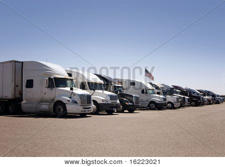 En rad av tunga godstransporter lastbilar parkerade i rad på en American highway truck stop