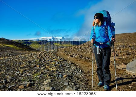 woman hiker on the trail in the Islandic mountains. woman standing and posing against the backdrop of a desert mountain landscape. Treking in National Park Landmannalaugar, Iceland. Travel photography concept