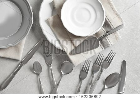 Cutlery set with plates on gray table,top view