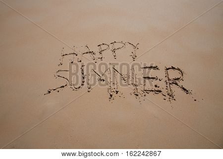 happy summer text written on brown sand ground at beach