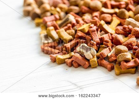 dry dog food in bulk on wooden background close up.