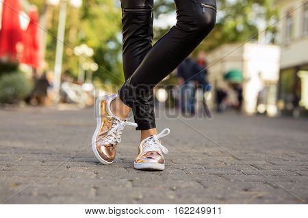 Modern woman in shinny sneakers in the city