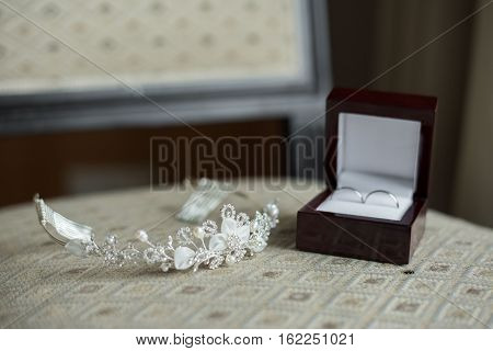 wedding rings in a brown box and a crown