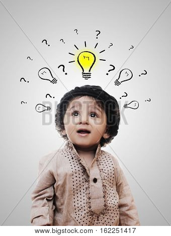 Adorable Intelligent Little Boy Thinking While Standing Before A White Background; Thinking Process With Chalk Board