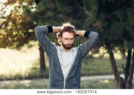 Excited man touching his head in park. Happy man feeling joy, happiness, pleasure of being in forest, free space. Overabundance of emotions, Indian summer, life love, new beginnings concept