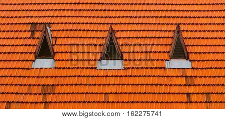 Background image of tiled roof attic window.