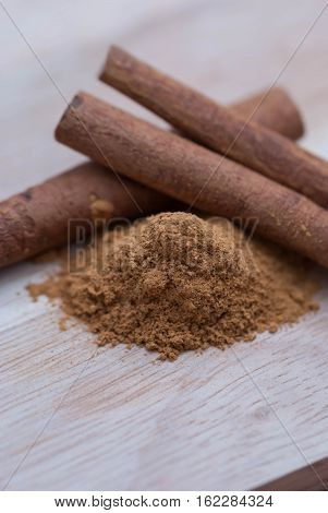 Cinnamon isolated on wooden background.Cinnamon powder with sticks