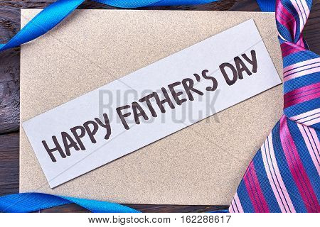 Father's Day card near tie. Ribbon and greeting card. Present for dear daddy.