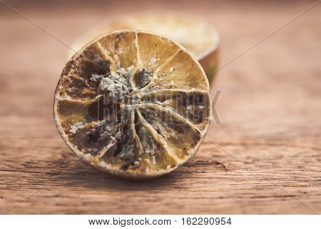Molded lemon on a wooden background.Molded lemon Macro