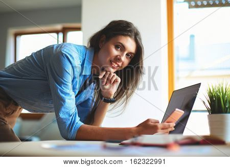 Young female businesswoman in the office near desk