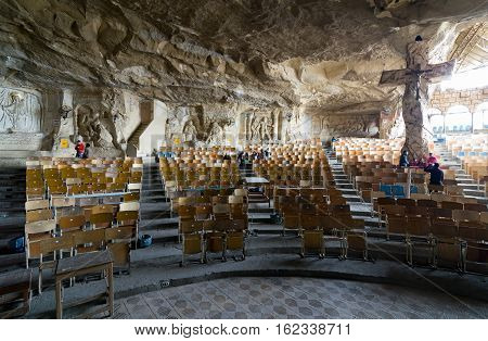Cairo, Egypt - December 18 2016: View of St. Samaan the Tanner Hall showing a big cross and walls decorated with murals of scenarios from the Bible at a huge cave, Saint Samaan The Tanner Monastery