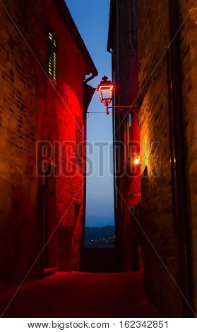 Night view of narrow alley with historic old houses in the medieval city of Castignano (Italy) during Templaria Festival