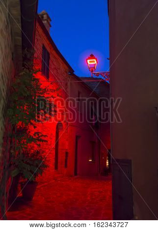 Night view of narrow alley with historic old houses in the medieval city of Castignano (Italy) during Templaria Festival