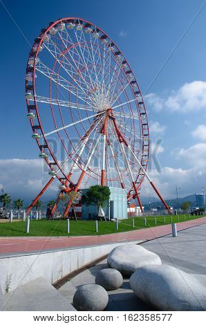 Ferris wheel on the Batumi seaside on sunny day with beautiful stone-shaped benches,Georgia, Adzharia