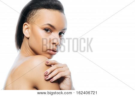 Mysterious woman. Elegant attractive young Negroid woman touching her skin while standing isolated in white background and expressing tenderness