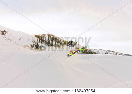 Freerider is jumping in the snow spray from the slope.