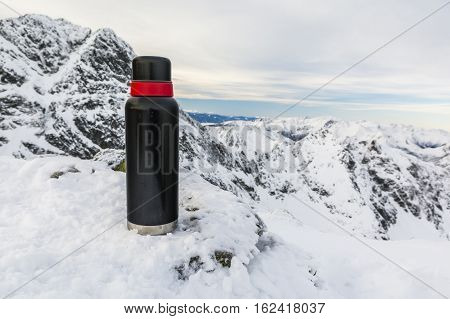 Thermos Of Tea In The Winter In The Mountains.