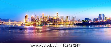 cityscape and skyline of downtown near water of chongqing at night