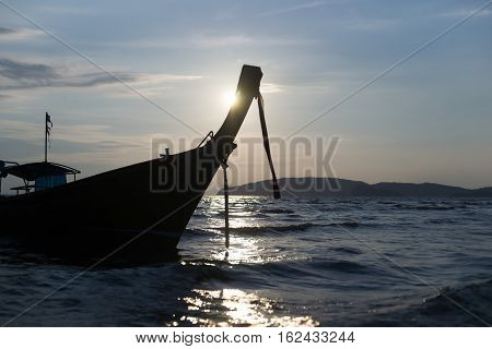 Traditional Thai boat is laid up in anticipation of tourists and passengers in the evening sun backlit