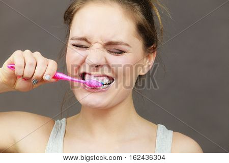 Woman brushing cleaning teeth. Girl with toothbrush. Oral hygiene. Dark background