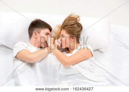 The young lovely couple lying in a white bed, love lconcept, top view