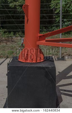 screws and nuts on the base of the red electric post from metal.