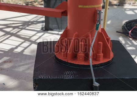 screws and nuts on the base of the red electric post from metal.