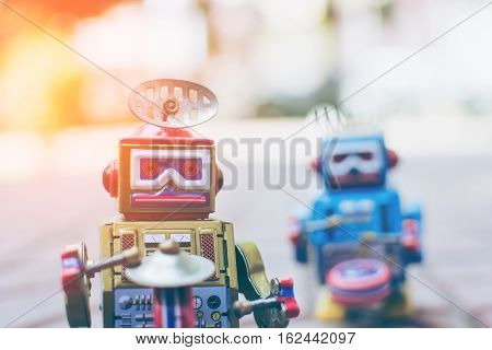 Retro robot toy on wood table, vintage color style, vintage tone background.