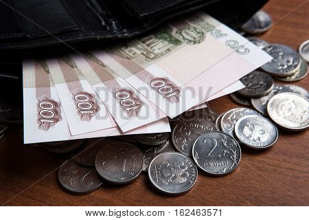 Russia's hundred-ruble banknotes and coins on the table closeup