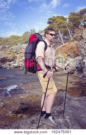 Summer hiking in the mountains with a backpack .