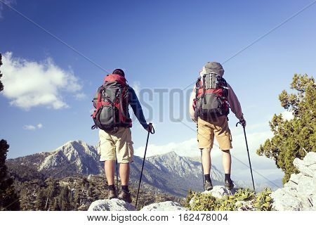 Summer hiking in the mountains with a backpack .