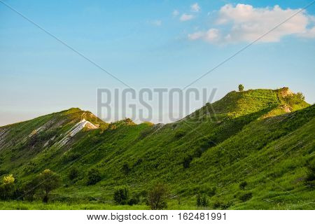 Green chalk hills under blue sky. The archaeological monument - Krapivinskaya settlement Belgorod region Russia.