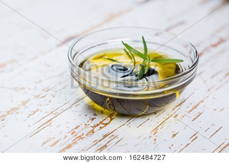 Olive oil with maslines on wood background, copy space