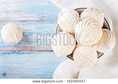 Plate of tasty zephyr on blue wooden table close up. sweet zephyrs on wood background.