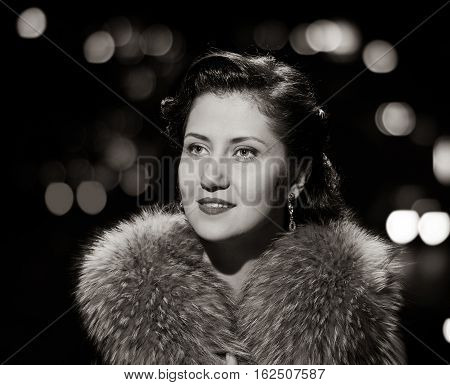 woman studio portrait in hollywood style light with night lights background. black and white variation
