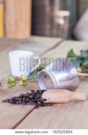Fresh coffee beans on wood with a moga pot
