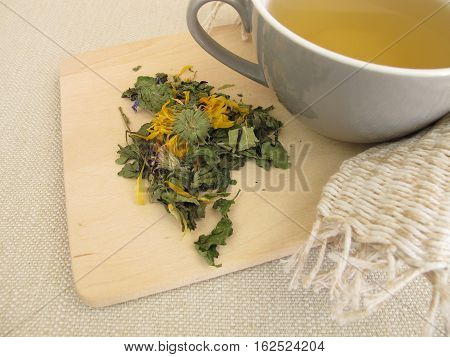 Cup of herbal tea with marigold and cornflower