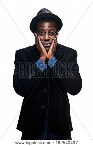 The portrait of handsome young black african unhappy man in hat on white background. Negative human emotions and power demonstration