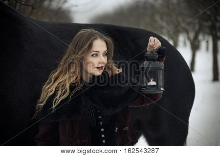 Girl In Dark Clothes With A Black Horse