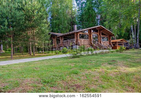 Valdaysky District, Russia - June 16, 2013: Little modern log cottage in a beautiful quiet location on the background of pines by Andrey Kopylov, aka linkpusher