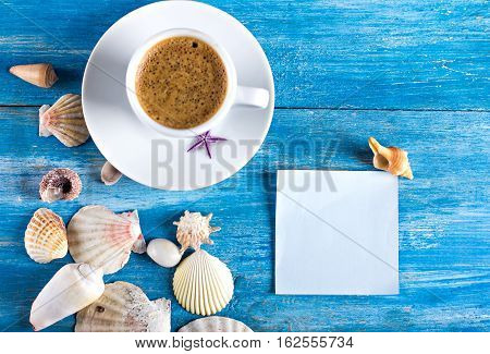 cup of coffee shells blue sticker on the old blue wooden boards sea style. marine still life