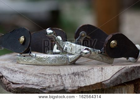 cowboy silver spurs with engraving on the wooden mat